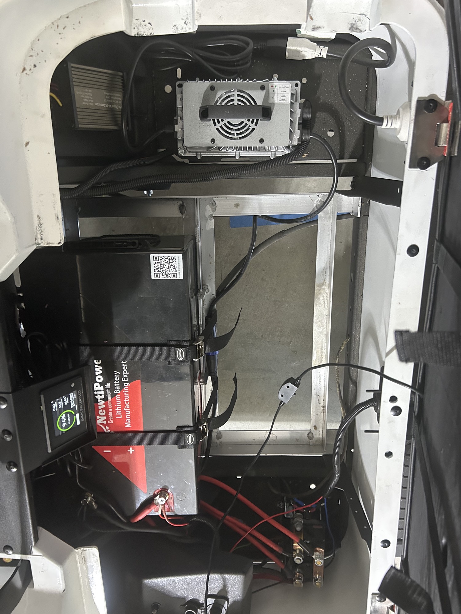 Lithium battery pack installed in the same golf cart bay, with open space where the lead batteries were