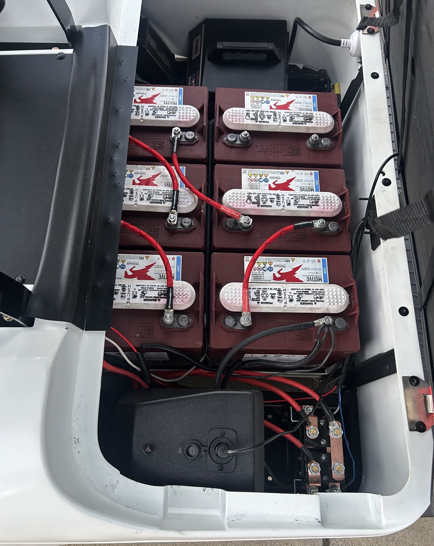 Six Trojan lead-acid batteries wired in a golf cart battery bay